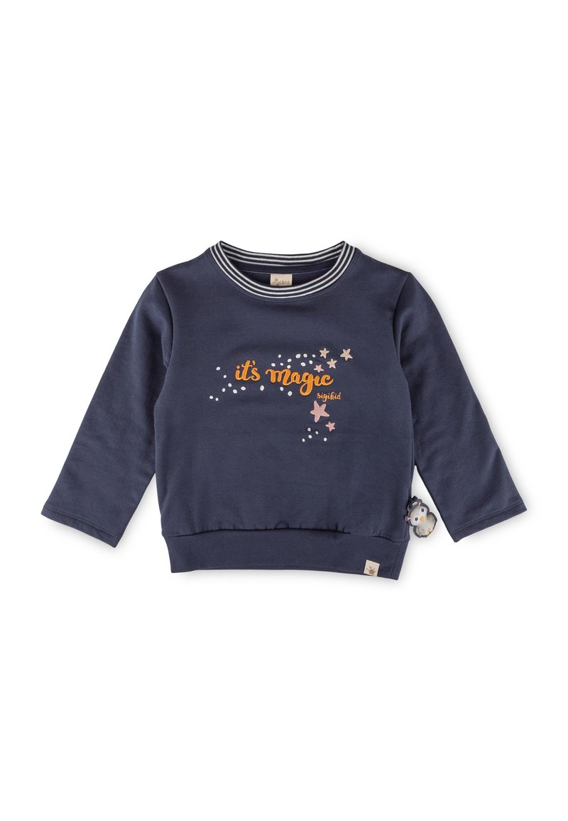 Maglione blu navy con maniche lunghe, colletto a righe e stampa "è magia" in arancione con stelle. Presenta un charm a forma di pinguino sul lato.