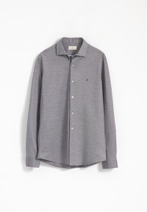 Camisa de botones de manga larga gris con cuello clásico, tela texturizada y pequeño logotipo en la parte izquierda del pecho. Los botones son de color plateado.
