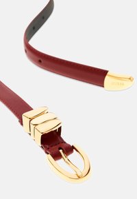 Curea din piele burgundă cu cataramă din metal aurit, având trei accente dreptunghiulare suprapuse și un capăt curbat.