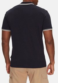 Polo shirt blu navy con dettagli bianchi sul colletto e sulle maniche. Maniche corte, forma aderente, realizzato in morbido cotone.