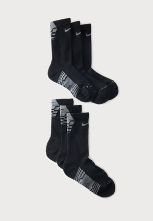 Έξι μαύρες κάλτσες Nike με γκρι λεπτομέρειες, τακτοποιημένες σε δύο τακτικές σειρές σε λευκό φόντο.