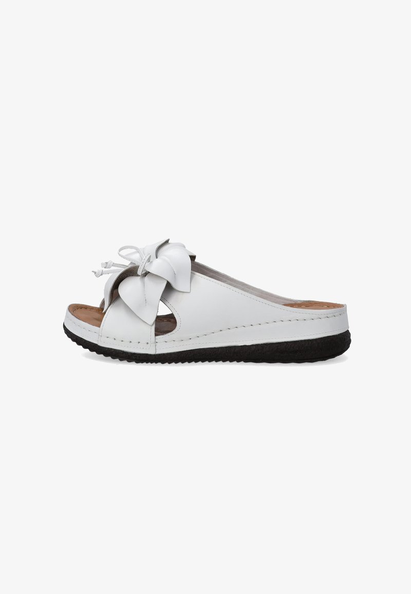 White leather slide sandals featuring a large decorative bow, open sides, and a textured black sole. Smooth interior with visible stitching.