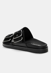 Schwarze Riemchensandalen aus glattem Leder, mit zwei silbernen Schnallenakzenten und einer strukturierten Gummisohle für besseren Halt.