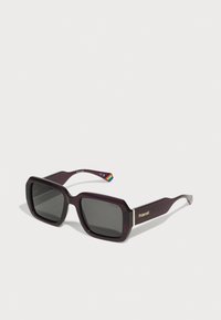 Purple square sunglasses with dark lenses, featuring a gold accent with "Polaroid" branding on the side and a rainbow detail on the arm.
