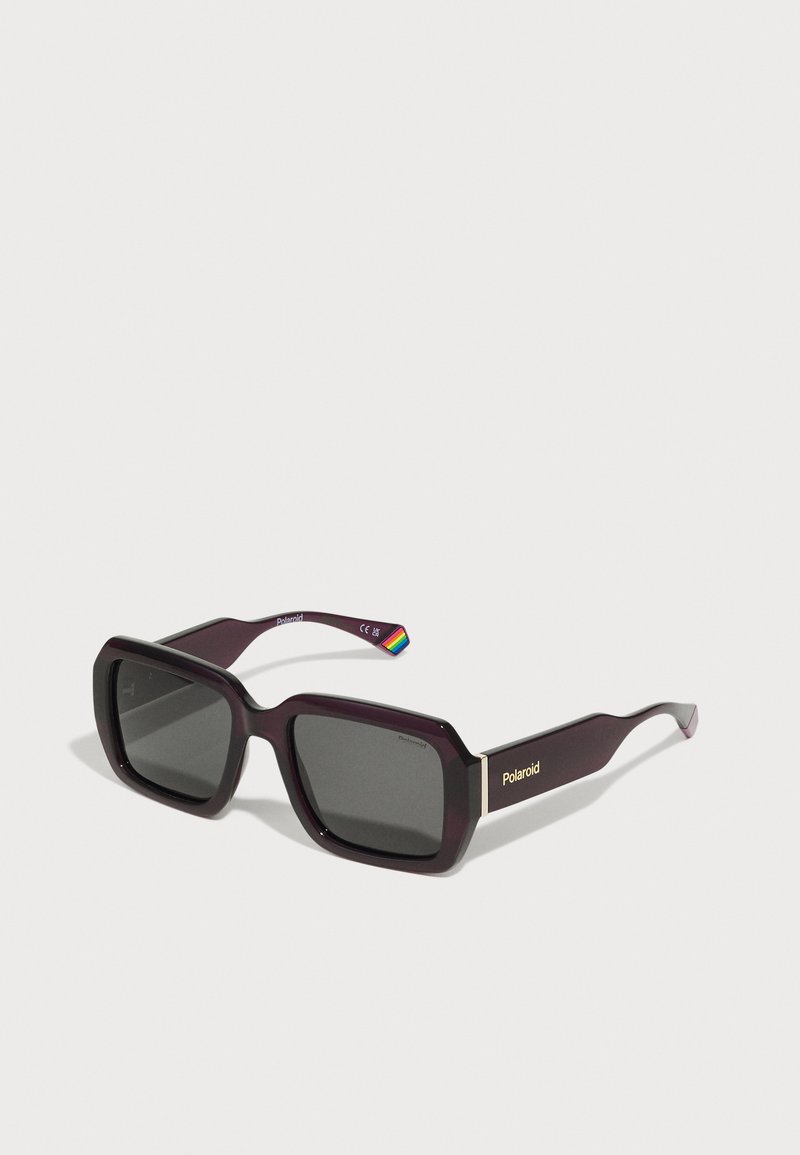 Purple square sunglasses with dark lenses, featuring a gold accent with "Polaroid" branding on the side and a rainbow detail on the arm.