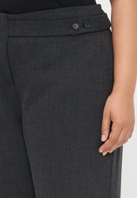 Dunkelgraue maßgeschneiderte Hosen aus strukturiertem Stoff, mit einem glatten Bund und zwei schwarzen Knöpfen sowie seitlichen Taschen.