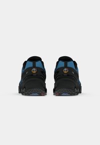 Black and blue athletic shoes with a textured mesh upper, rear pull tab, and flexible outsole. Features prominent logo on the heel.