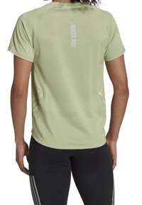 Jasnozielona sportowa koszulka z krótkimi rękawami o mikroperforowanej fakturze, z odblaskowym logo na plecach i luźnym krojem.
