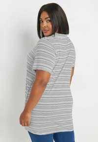 Randig T-shirt i svart och vitt, kort ärm, med en avslappnad passform och rundad nederkant. Mjuk, lättviktig tyg; avslappnad design.