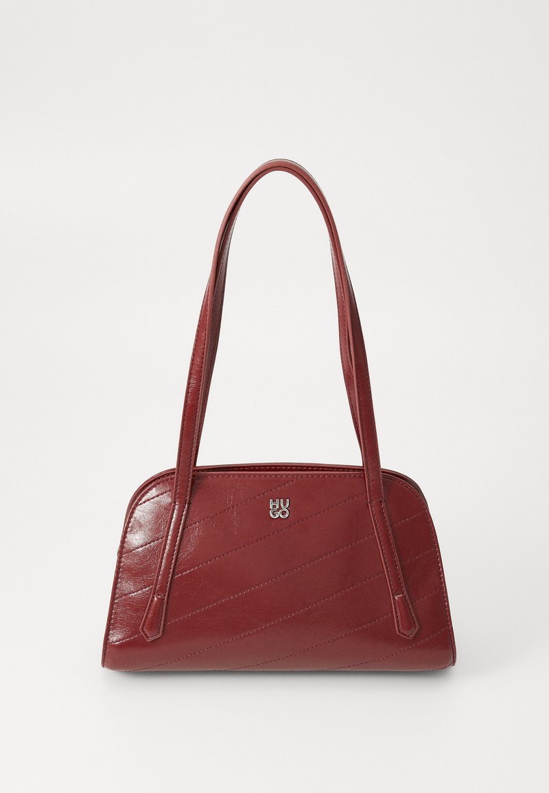 Borsa a spalla trapuntata rossa realizzata in materiale lucido, con due manici lunghi e un'accento con logo argentato. La cucitura diagonale crea una texture.