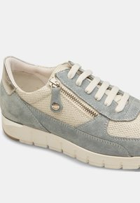 Helehall sinine ja beež sneaker, mis on valmistatud seemisnahast ja võrkkangast. Sellel on tõmblukk, lameda paelaga ja paks valge tald, millel on tekstuuriga muster.
