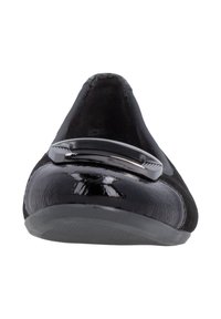 Chaussures plates noires avec un dessus en daim texturé et un bout en cuir verni brillant. Dotées d'un accent métallique sur le cou-de-pied et d'une semelle en caoutchouc flexible.