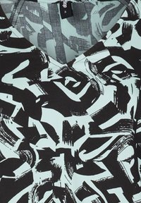 Modello astratto in bianco e nero con pennellate su uno sfondo verde menta; presenta un scollo a V e un tessuto morbido e leggero.