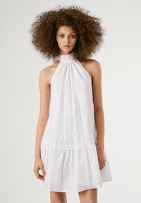 Vestido branco de alças com fundo franzido, feito de tecido leve. Textura suave, ajuste solto e design minimalista.