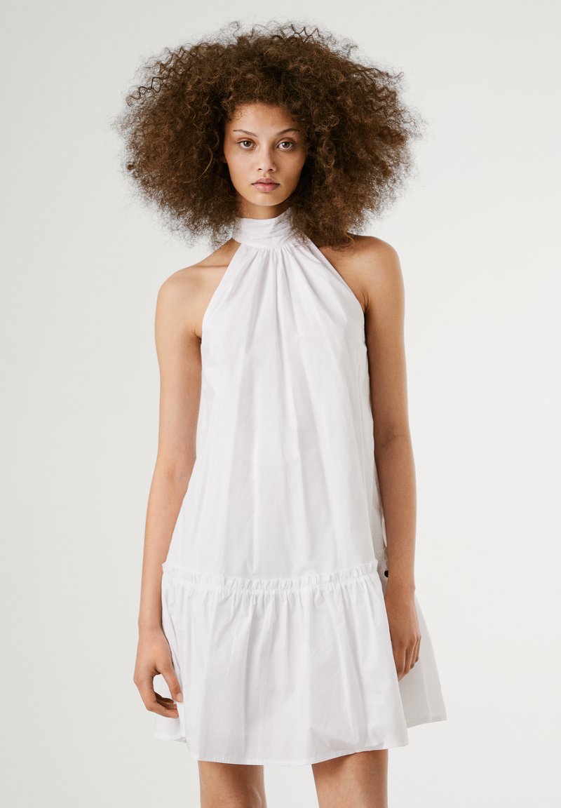 Vestido branco de alças com fundo franzido, feito de tecido leve. Textura suave, ajuste solto e design minimalista.