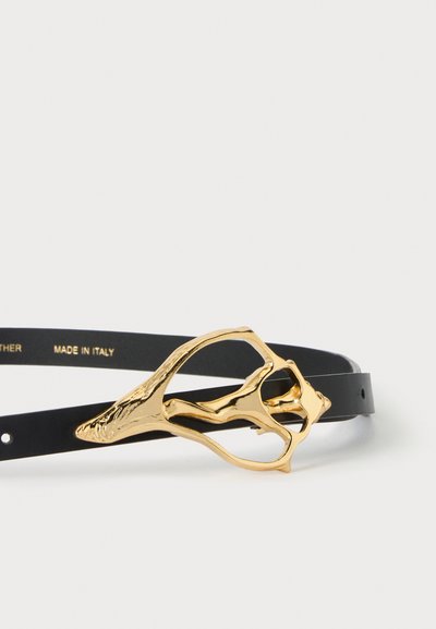 Ceinture en cuir noir avec une boucle abstraite dorée distinctive, marquée "Made in Italy,", affichée sur fond blanc.