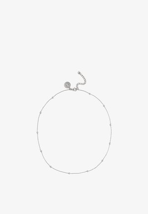 Delicata collana a catena in argento con piccole perline rotonde distribuite uniformemente e un ciondolo circolare con marchio vicino al moschettone e alla catena di estensione.
