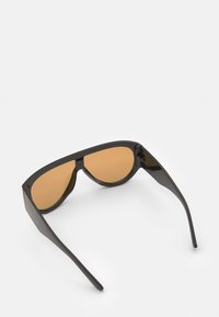 Ochelari de soare negri cu lentile maro, având un design unghiular elegant și un cadru din plastic, prezentând un mecanism de balama pliabil.