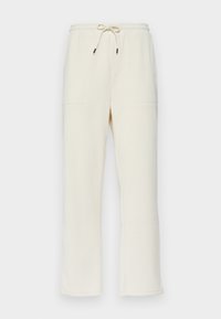Cremefarvede ribbede sweatpants med snor i taljen, der har to sidelommer og et lige ben-design.