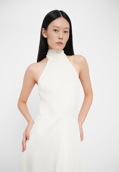 Rochie fără mâneci cu gât halter dintr-un material alb-cremos, cu un corset ajustat și o cădere lejeră, evidențiind textura netedă și liniile curate.