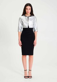 Zilveren cropped jasje met driekwart mouwen, gecombineerd met een zwarte aansluitende kokerrok. Glad textuur, lengte tot de knie en minimalistische details.