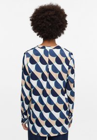 Langärmlige Bluse aus weichem Stoff mit einem geometrischen Muster in Marineblau, Beige und Türkis, mit Knopfmanschetten und abgerundetem Saum.