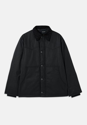 Black canvas jacket with a button closure, contrasting textured collar, side pockets, and subtle seam detailing. No visible logos.