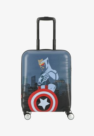 Valigia rigida con un design grafico di un supereroe, prevalentemente blu con uno scudo circolare rosso e bianco, quattro ruote e manico telescopico.