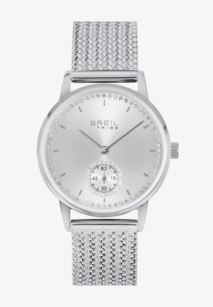 Montre argentée avec un bracelet en acier inoxydable en maille, face ronde, accents en cristal autour du cadran et un sous-cadran plus petit pour les secondes.