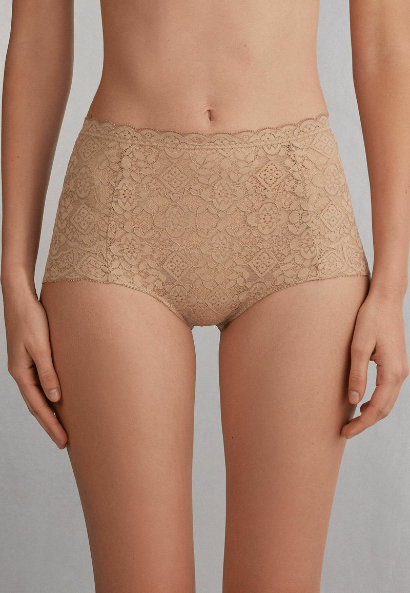 Naakt kanten hipster ondergoed met bloemmotieven, golvende randen en een gladde textuur, ontworpen voor comfort en bedekking.