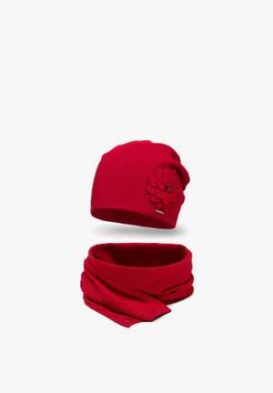 Červená pletená čepice s květinovým akcentem, doplněná o odpovídající červený šál. Oba kousky mají měkkou, texturovanou tkaninu a jsou těsně přiléhající.