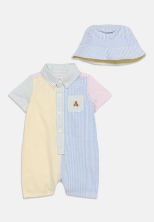 Baby romper kratkih rukava s gumbima, u pastelnim prugama, s prednjim džepom i vezenim medvjedićem, u kombinaciji s odgovarajućom prugastom kapom sa širokim obodom.