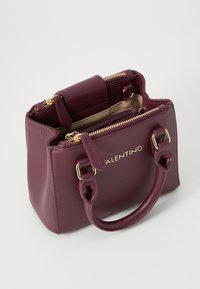 Borsa a mano strutturata color bordeaux con finiture dorate, manici doppi e scomparti con zip; realizzata in materiale sintetico texture.