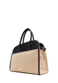 Beige canvas bag with black leather accents, double handles, and gold-tone hardware. Features visible stitching and a sleek silhouette.