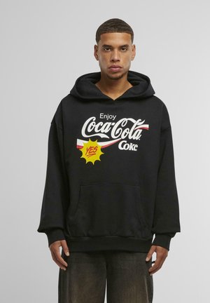 Black hooded sweatshirt with a front pocket featuring Coca-Cola logo, yellow "YES" graphic, and red accents on white stripes.