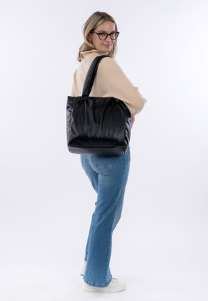 Sac fourre-tout en cuir noir avec un design plissé, deux longues poignées et une forme structurée. Texture lisse avec un doux éclat.