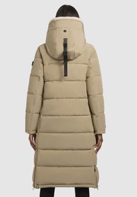 Beidzs pufīgs mētelis ar lielu kapuci, izšūts dizains, sānu rāvējslēdzēji un teksturēta iekšpuse. Aizmugurē ir logo birka.