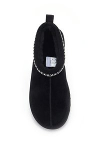 Crne nubuk papuče s mekanim krznom iznutra, ukrasnim bijelim šavovima oko otvora i s petljom za lako obuvanje.
