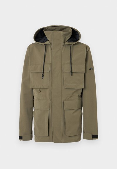 Πράσινο μπουφάν με κουκούλα σε ελιά χρώμα, με φερμουάρ μπροστά, τέσσερις τσέπες με καπάκι, ρυθμιζόμενες λουρίδες στον καρπό και μαύρα κορδόνια στην κουκούλα.