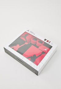Jordan 5-piece set in red and black includes socks and booties. Box features a clear top with silhouette designs and logo accents.