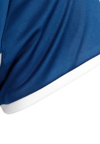 Maglia sportiva blu con una texture liscia, caratterizzata da un bordo bianco all'orlo. Il design include una leggera lucentezza e una forma aderente.