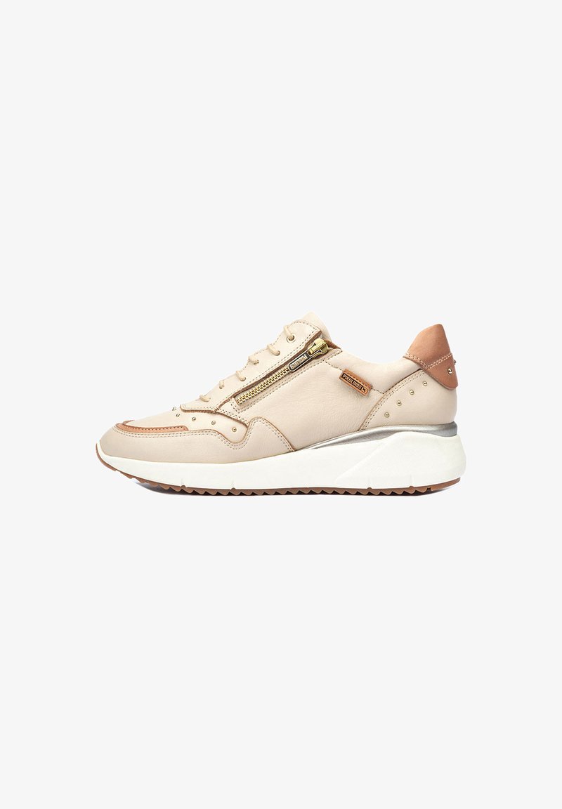 Zapatillas de cuero beige con detalles metálicos, cremalleras decorativas y una suela media blanca. Cuenta con una suela exterior de goma marrón texturizada.