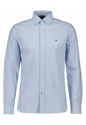 Hellblaues, langärmeliges Hemd mit weißen und gelben vertikalen Streifen und einem kleinen gestickten Logo auf der linken Brust.