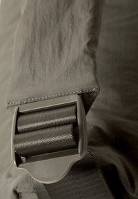 Gray fabric strap with textured finish, featuring a metallic buckle made of durable hardware, designed for secure fastening.