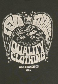 Schwarzes T-Shirt mit einem Graphikdruck eines Adlers mit flügeln, Text "LEVI STRAUSS & CO" und "QUALITÄTSKLEIDUNG", akzentuiert durch Sterne.