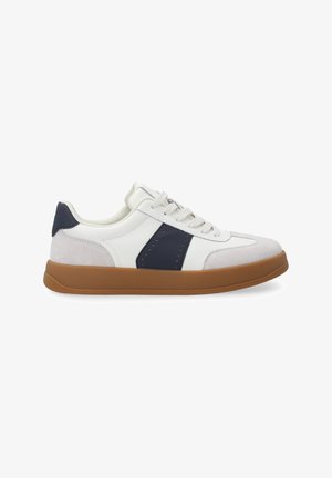 Weiße und marineblaue Sneaker aus Leder und Wildleder mit einer braunen Gummisohle, ausgestattet mit Perforierungen und flachen Schnürsenkeln.