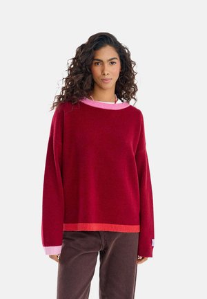 Czerwono-różowy sweter z blokowaniem kolorów, o szerokim, okrągłym dekolcie, długich rękawach oraz ściągaczach na rękawach i dole, wykonany z miękkiego materiału.