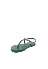 Chanclas de goma verdes con suela texturizada, tiras finas con un patrón de espiga y un pequeño acento dorado cerca del separador de los dedos.