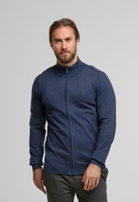  Marineblaues Zip-Up-Pullover mit hohem Kragen, langen Ärmeln, gerippten Bündchen und dezentem strukturiertem Detail im gesamten Stoff.