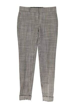 Pantalon slim à carreaux noir et blanc avec ourlets retournés et taille ajustée, présenté à plat sur fond blanc.